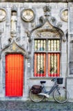 Vada in bicicletta fuori di una proprietà nel quadrato Bruges le Fiandre Occidentali del mercato immagine stock libera da diritti Vada in bicicletta fuori di una proprietà nel quadrato Bruges le Fiandre Occidentali del mercato immagine stock libera da diritti