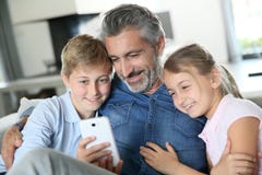 Vader die met jonge geitjes op smartphone spelen royalty-vrije stock fotografie Vader die met jonge geitjes op smartphone spelen royalty-vrije stock fotografie