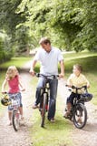 Vader en kinderen die fietsen in platteland berijden royalty-vrije stock fotografie Vader en kinderen die fietsen in platteland berijden royalty-vrije stock fotografie