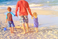 Vader en twee jonge geitjes die op strand lopen Royalty-vrije Stock Foto Vader en twee jonge geitjes die op strand lopen Royalty-vrije Stock Foto