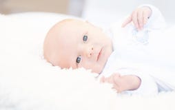 Vakna nyfött med ögon som är öppna i bekväm längsgående stödbjälkepyjamas på a royaltyfri fotografi Vakna nyfött med ögon som är öppna i bekväm längsgående stödbjälkepyjamas på a royaltyfri fotografi
