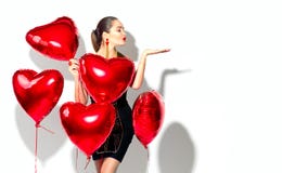 valentin för dag s Skönhetflickan med röd hjärta formade luftballonger som har gyckel royaltyfri bild valentin för dag s Skönhetflickan med röd hjärta formade luftballonger som har gyckel royaltyfri bild