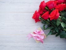 Valentine background of gift box with ribbon and bow and bunch of red roses on wood. Space for copy. royalty free stock photos Valentine background of gift box with ribbon and bow and bunch of red roses on wood. Space for copy. royalty free stock photos