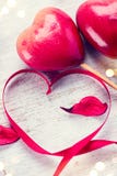 Valentine`s Day. Elegant red satin gift ribbon and couple of red hearts stock photo Valentine`s Day. Elegant red satin gift ribbon and couple of red hearts stock photo