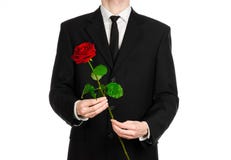 Valentine's Day and Women's Day theme: man's hand in a suit holding a red rose isolated on white background in studio stock photography Valentine's Day and Women's Day theme: man's hand in a suit holding a red rose isolated on white background in studio stock photography