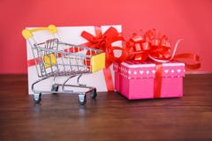 Valentines day shopping and Gift card Gift Box Shopping cart Pink present box with red ribbon bow gift card royalty free stock image Valentines day shopping and Gift card Gift Box Shopping cart Pink present box with red ribbon bow gift card royalty free stock image
