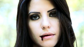 Vampiro femenino que sonríe con sangre en boca Vampiro femenino que sonríe con sangre en boca