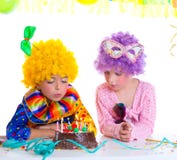 Van de de verjaardagspartij van kinderen de clownpruiken die cakekaarsen blazen stock afbeeldingen Van de de verjaardagspartij van kinderen de clownpruiken die cakekaarsen blazen stock afbeeldingen