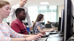 Van de de Schoolstudent van leraarshelping male high de Klasse van Working In Computer stock footage Van de de Schoolstudent van leraarshelping male high de Klasse van Working In Computer stock footage