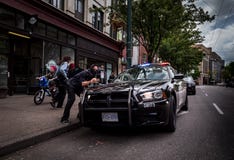 VANCOUVER ORIENTALE, BC, IL CANADA - 11 MAGGIO 2016: L'uomo con un bandanna che copre il suo fronte mostra il a mano segno per Va fotografie stock libere da diritti VANCOUVER ORIENTALE, BC, IL CANADA - 11 MAGGIO 2016: L'uomo con un bandanna che copre il suo fronte mostra il a mano segno per Va fotografie stock libere da diritti