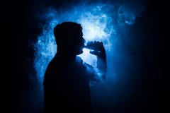 Vapingsmens die mod. houden Een wolk van damp Zwarte achtergrond Vaping een elektronische sigaret met heel wat rook Vapeconcept royalty-vrije stock foto Vapingsmens die mod. houden Een wolk van damp Zwarte achtergrond Vaping een elektronische sigaret met heel wat rook Vapeconcept royalty-vrije stock foto
