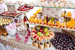 Variety of sweet desserts with fruits and alcohol drinks on the