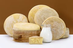 Various Hard Parmesan Cheese On The White Table With A Jug Milk Stock Photos
