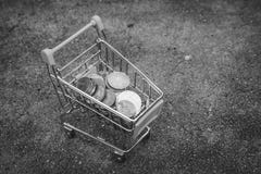 Various money coins Baht in yellow mini shopping cart or supermarket trolley set on concrete floor in black and white image. royalty free stock images Various money coins Baht in yellow mini shopping cart or supermarket trolley set on concrete floor in black and white image. royalty free stock images