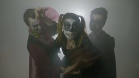 Varones de Halloween y lucha femenina y el atacar del zombi rodeados por la niebla - almacen de video Varones de Halloween y lucha femenina y el atacar del zombi rodeados por la niebla - almacen de video