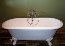 Vasca da bagno bianca contro il fondo di verde verde oliva immagine stock libera da diritti Vasca da bagno bianca contro il fondo di verde verde oliva immagine stock libera da diritti