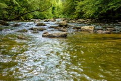 Vasto scorrimento dell'acqua del fiume attraverso le montagne di cresta blu fotografia stock Vasto scorrimento dell'acqua del fiume attraverso le montagne di cresta blu fotografia stock