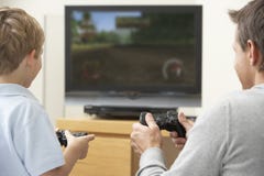 Vater und junger Sohn, die mit Spiel-Konsole spielen Vater und junger Sohn, die mit Spiel-Konsole spielen