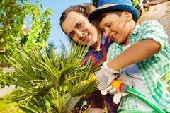 Vater und Sohn, die im Garten zusammenarbeiten lizenzfreie stockbilder Vater und Sohn, die im Garten zusammenarbeiten lizenzfreie stockbilder