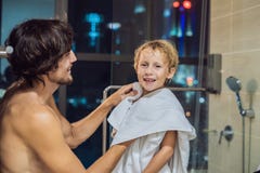 Vati wischt seinen Sohn mit einem Tuch nach einer Dusche am Abend ab, bevor er geht, auf dem Hintergrund eines Fensters mit a zu stockfotografie Vati wischt seinen Sohn mit einem Tuch nach einer Dusche am Abend ab, bevor er geht, auf dem Hintergrund eines Fensters mit a zu stockfotografie