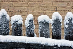 Vecchi di legno recintano la neve contro un fondo del muro di mattoni Fotografia Stock Vecchi di legno recintano la neve contro un fondo del muro di mattoni Fotografia Stock
