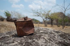 Vecchia latta arrugginita su una roccia in un deserto fotografie stock Vecchia latta arrugginita su una roccia in un deserto fotografie stock