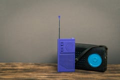 Vecchia radio sulla tavola di legno con il fondo della parete di colore fotografia stock Vecchia radio sulla tavola di legno con il fondo della parete di colore fotografia stock