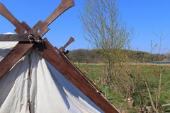 Vecchia tenda di vichingo fatta del panno e del legno davanti ad un cielo blu fotografia stock Vecchia tenda di vichingo fatta del panno e del legno davanti ad un cielo blu fotografia stock