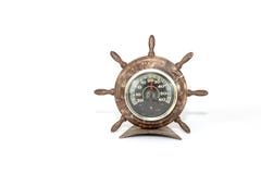 Vecchio barometro marrone sotto forma di timone del volante della nave isolato su un fondo bianco fotografia stock Vecchio barometro marrone sotto forma di timone del volante della nave isolato su un fondo bianco fotografia stock