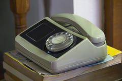 Vecchio telefono bianco messo sul libro immagini stock libere da diritti Vecchio telefono bianco messo sul libro immagini stock libere da diritti