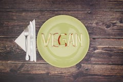 Vegano di parola sul piatto verde fotografia stock Vegano di parola sul piatto verde fotografia stock