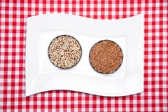 Vegetable food. A decorative white plate with two bowls with buckwheat and quinoa on a red checkered tablecloth. Healthy eating. royalty free stock photo Vegetable food. A decorative white plate with two bowls with buckwheat and quinoa on a red checkered tablecloth. Healthy eating. royalty free stock photo