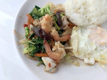 Vegetable блюдо stir-фрая с тайской здоровой едой stir-зажарило брокколи, гриб, морковь, hearb, кальмара и креветку с рисом и заж Стоковые Изображения RF Vegetable блюдо stir-фрая с тайской здоровой едой stir-зажарило брокколи, гриб, морковь, hearb, кальмара и креветку с рисом и заж Стоковые Изображения RF