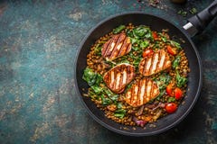 Vegetarian food concept. Healthy lentil dish with spinach and fried cheese in cooking pan on rustic background with ingredients royalty free stock images Vegetarian food concept. Healthy lentil dish with spinach and fried cheese in cooking pan on rustic background with ingredients royalty free stock images