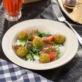 Vegetarian green salad with falafel and glass of tomato juice on the table royalty free stock images Vegetarian green salad with falafel and glass of tomato juice on the table royalty free stock images