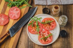 хVegetarian Salad. Tomato With Arugula And Seasonings In A White Bowl On A Wooden Background. Top View Royalty Free Stock Image хVegetarian Salad. Tomato With Arugula And Seasonings In A White Bowl On A Wooden Background. Top View Royalty Free Stock Image