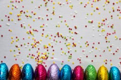 Velen richtten gekleurde chocoladepaaseieren op witte achtergrond en kleurrijke confettien royalty-vrije stock foto's Velen richtten gekleurde chocoladepaaseieren op witte achtergrond en kleurrijke confettien royalty-vrije stock foto's