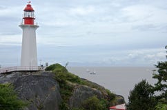 Veleros en el mar y el faro en la roca de la costa foto de archivo Veleros en el mar y el faro en la roca de la costa foto de archivo