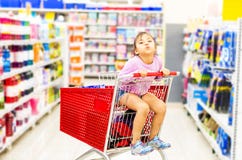 Venda, consumi??o e conceito dos povos - menina feliz no carrinho de compras imagem de stock Venda, consumi??o e conceito dos povos - menina feliz no carrinho de compras imagem de stock