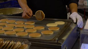 Vendedor de la cámara lenta que cocina dorayaki en los soportes de borde de la carretera Asia Crepe asi?tica almacen de metraje de vídeo Vendedor de la cámara lenta que cocina dorayaki en los soportes de borde de la carretera Asia Crepe asi?tica almacen de metraje de vídeo