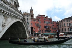Gondola is passing along the Grand canal under the beautiful Rialto bridge in a sunny spring day. stock photos Gondola is passing along the Grand canal under the beautiful Rialto bridge in a sunny spring day. stock photos