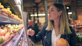 Vente, nourriture, achats, consommationisme et concept de personnes Femme blonde choisissant des fruits des étagères colorées ded banque de vidéos Vente, nourriture, achats, consommationisme et concept de personnes Femme blonde choisissant des fruits des étagères colorées ded banque de vidéos