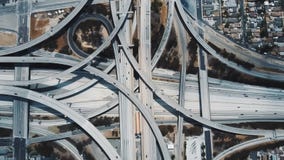Verbazende luchtlockdownmening van auto's die zich door de grote complexe uitwisseling van de wegverbinding in Los Angeles, de V. stock video Verbazende luchtlockdownmening van auto's die zich door de grote complexe uitwisseling van de wegverbinding in Los Angeles, de V. stock video