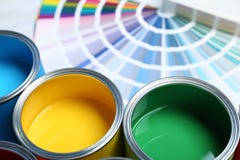 Verfblikken en de steekproeven van het kleurenpalet op lijst stock fotografie Verfblikken en de steekproeven van het kleurenpalet op lijst stock fotografie
