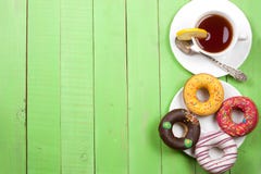 Verglaasd donuts met een kop thee op een groene houten achtergrond met exemplaarruimte voor uw tekst Hoogste mening royalty-vrije stock fotografie Verglaasd donuts met een kop thee op een groene houten achtergrond met exemplaarruimte voor uw tekst Hoogste mening royalty-vrije stock fotografie