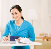 Verificación de la escritura de la mujer del talonario de cheques Imágenes de archivo libres de regalías Verificación de la escritura de la mujer del talonario de cheques Imágenes de archivo libres de regalías
