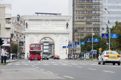 Verkehr und Doubledeckerbus vor mazedonischem Tor in Skopje, das eins der vielen Monumente ist stockbild Verkehr und Doubledeckerbus vor mazedonischem Tor in Skopje, das eins der vielen Monumente ist stockbild