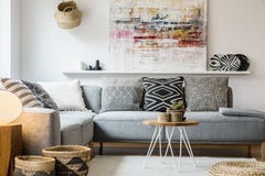 Verkligt foto av en hemtrevlig soffa med kuddar som står bak ett litet royaltyfri foto Verkligt foto av en hemtrevlig soffa med kuddar som står bak ett litet royaltyfri foto