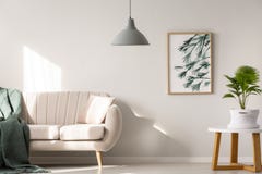 Verkligt foto av en soffa med filt- och kuddeanseende bredvid a arkivfoto Verkligt foto av en soffa med filt- och kuddeanseende bredvid a arkivfoto