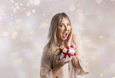Verraste vrouw die sommige Kerstmisgiften houden stock afbeeldingen Verraste vrouw die sommige Kerstmisgiften houden stock afbeeldingen